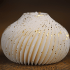 Bougie boule torsadée artisanale en cire naturelle, ornée d'éclats dorés pour une touche élégante et raffinée, idéale pour une décoration intérieure sophistiquée.