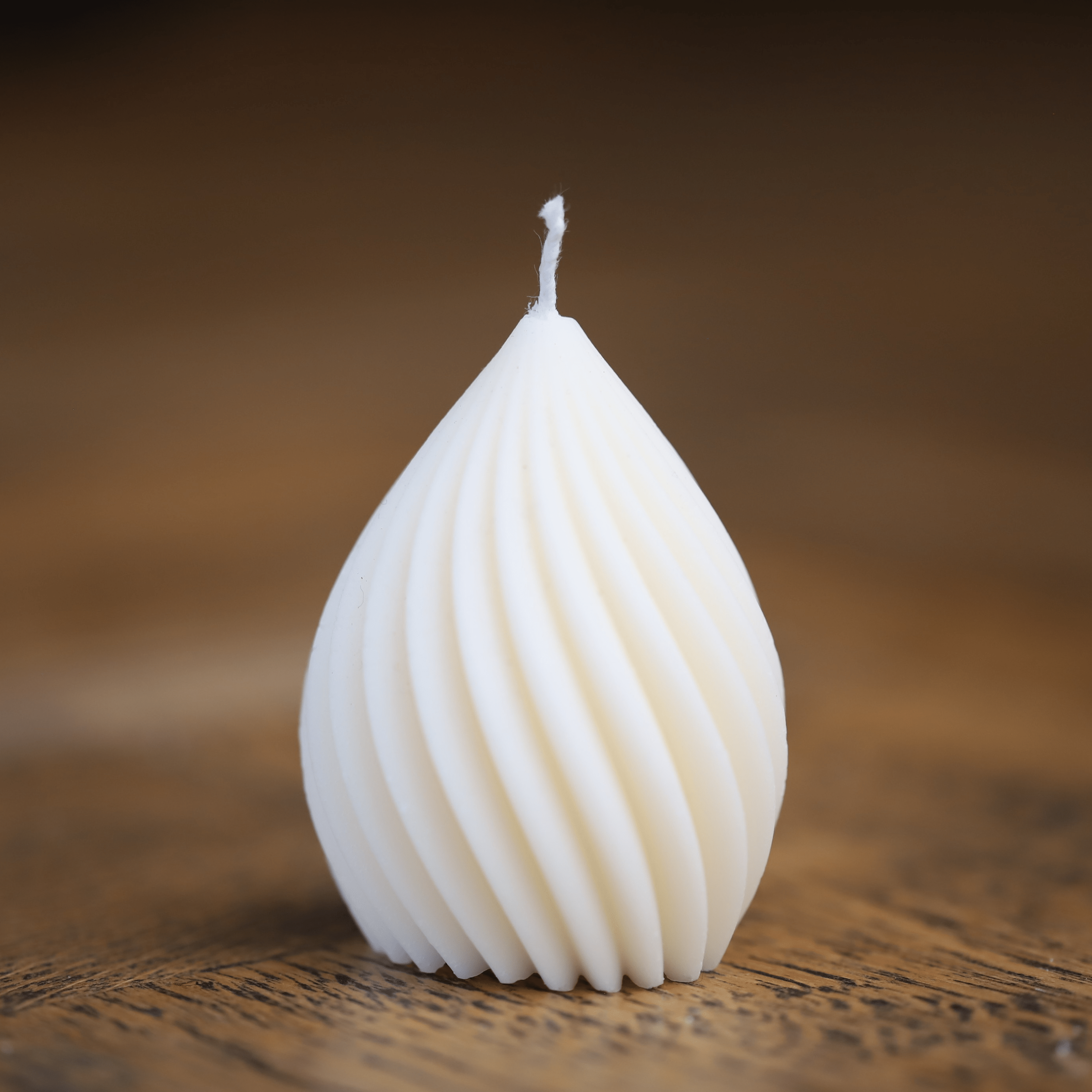 Bougie goutte torsadée en cire blanche, au design élégant et sculptural, fabriquée artisanalement en Alsace. Parfaite pour une décoration intérieure minimaliste et raffinée.