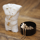 Bougie artisanale en forme de buste masculin, sublimée par des éclats de feuilles d'or qui mettent en valeur la musculature détaillée. Cette pièce décorative apporte une touche d'élégance et de caractère à tout intérieur, idéale pour une ambiance chic et raffinée.