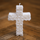 Bougie artisanale en forme de croix avec motif de roses, idéale pour une décoration religieuse et spirituelle.