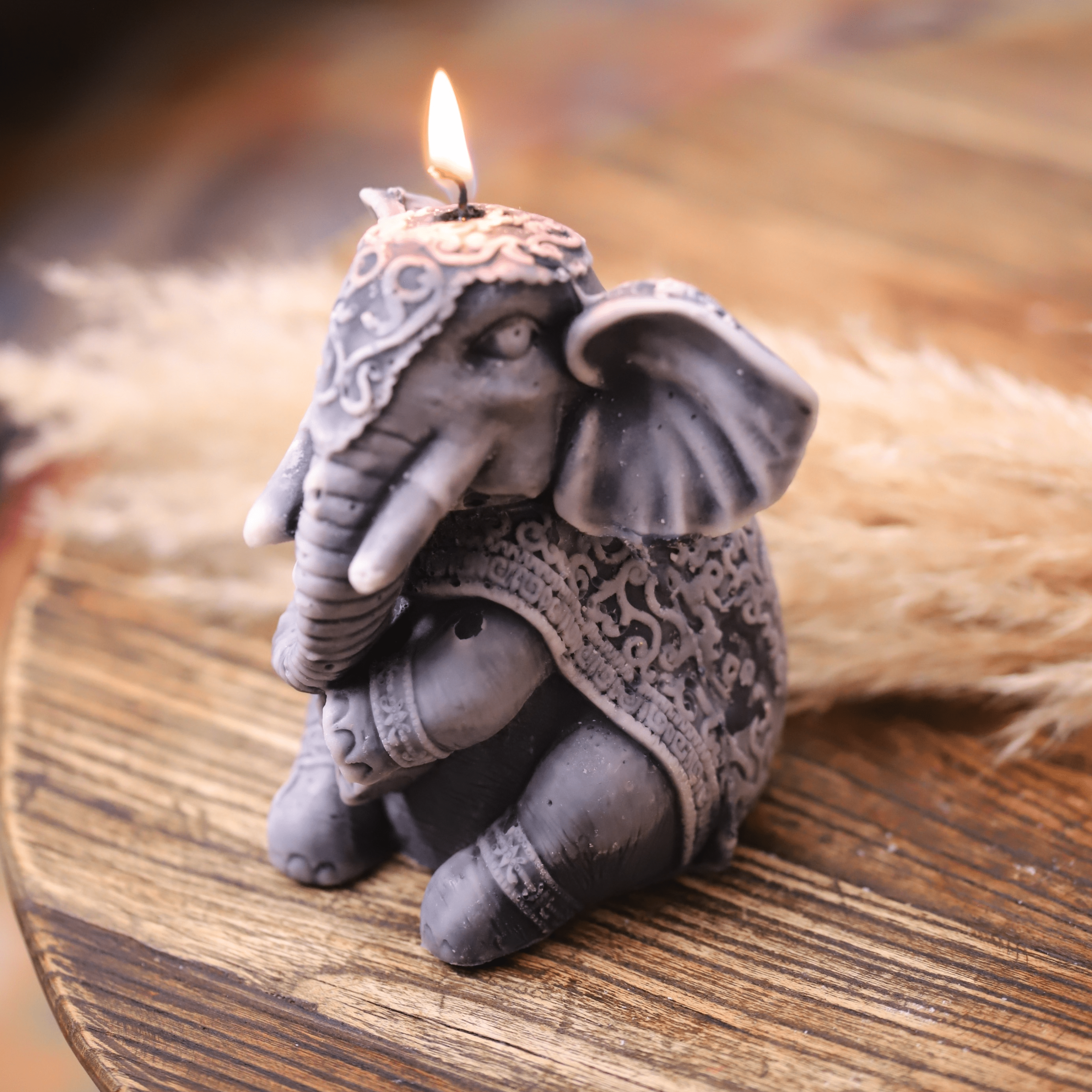 Bougie artisanale sculptée en forme d'éléphant, avec une finition grise élégante et des motifs détaillés. Idéale pour une décoration exotique et chaleureuse, elle apportera une touche raffinée à votre intérieur. Parfaite pour les amoureux des éléphants et de l'artisanat.