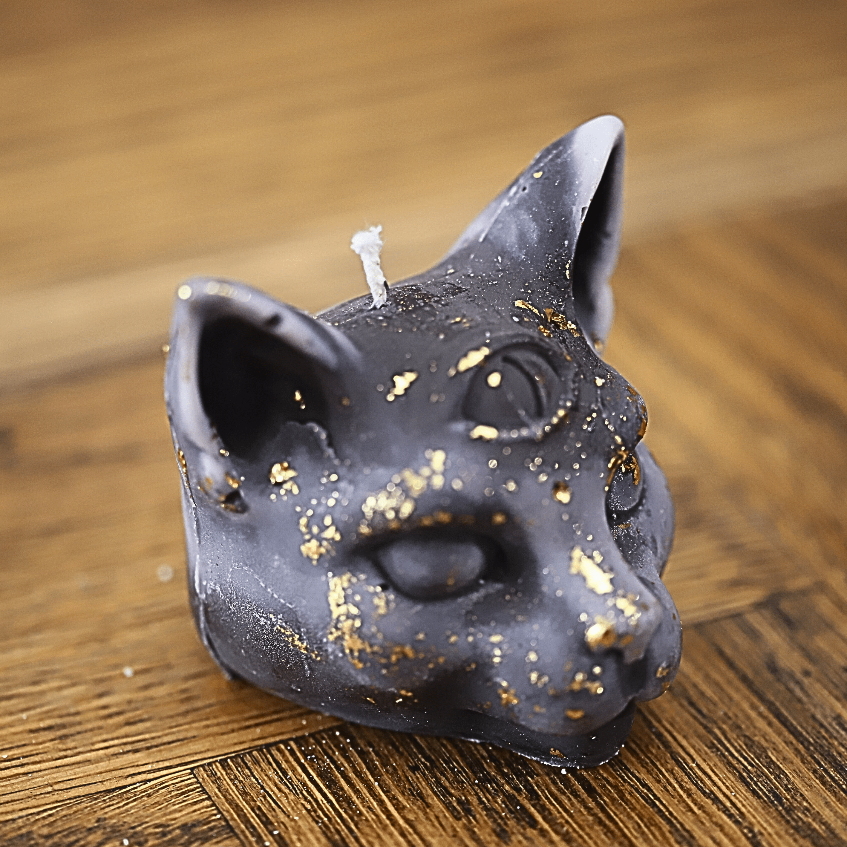Bougie artisanale en cire naturelle en forme de tête de chat avec un troisième œil et des éclats dorés, parfaite pour une décoration ésotérique et mystique.