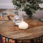 Bougie boule torsadée avec éclats dorés mise en valeur dans une décoration de table élégante, apportant une touche chaleureuse et raffinée à votre intérieur.