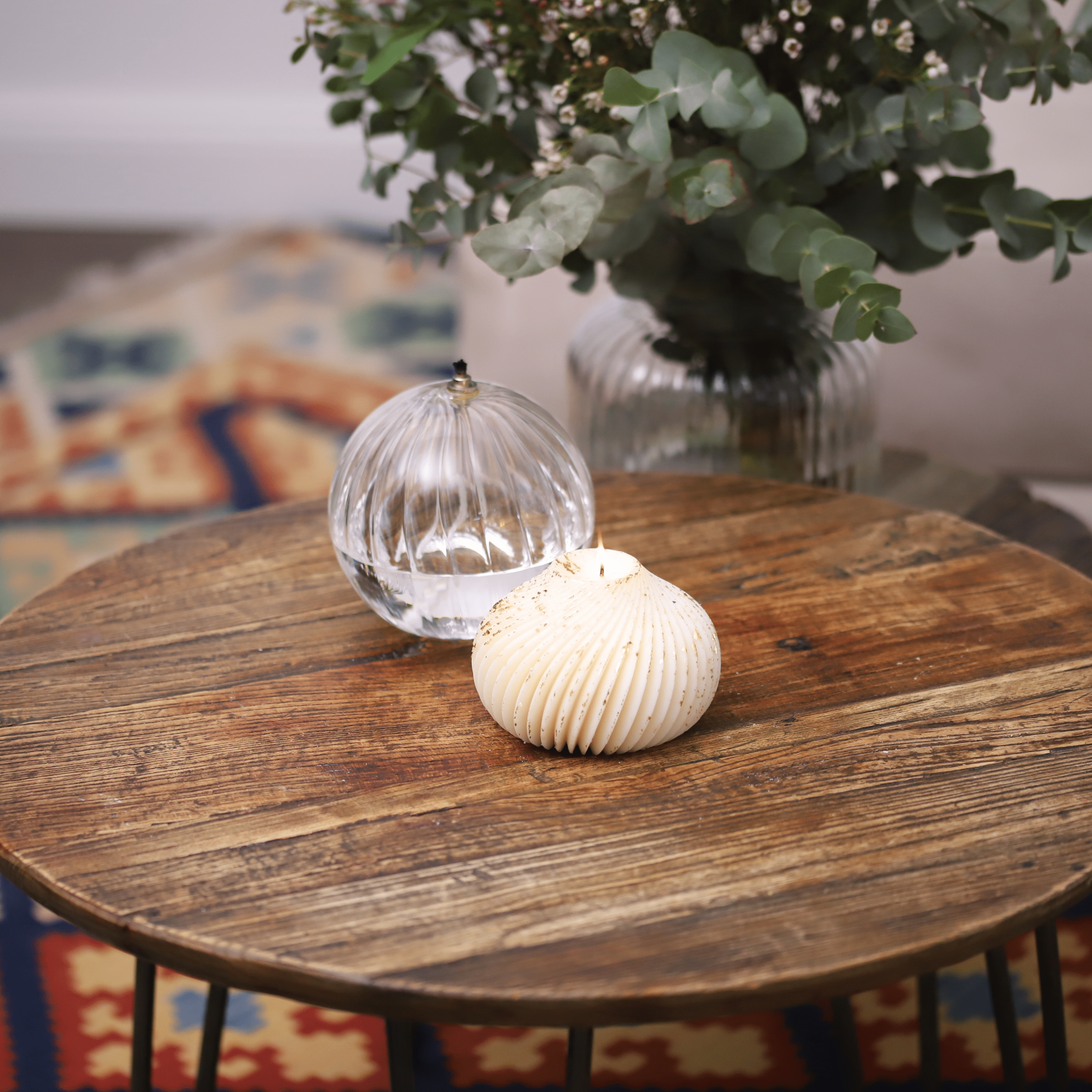Bougie boule torsadée avec éclats dorés mise en valeur dans une décoration de table élégante, apportant une touche chaleureuse et raffinée à votre intérieur.