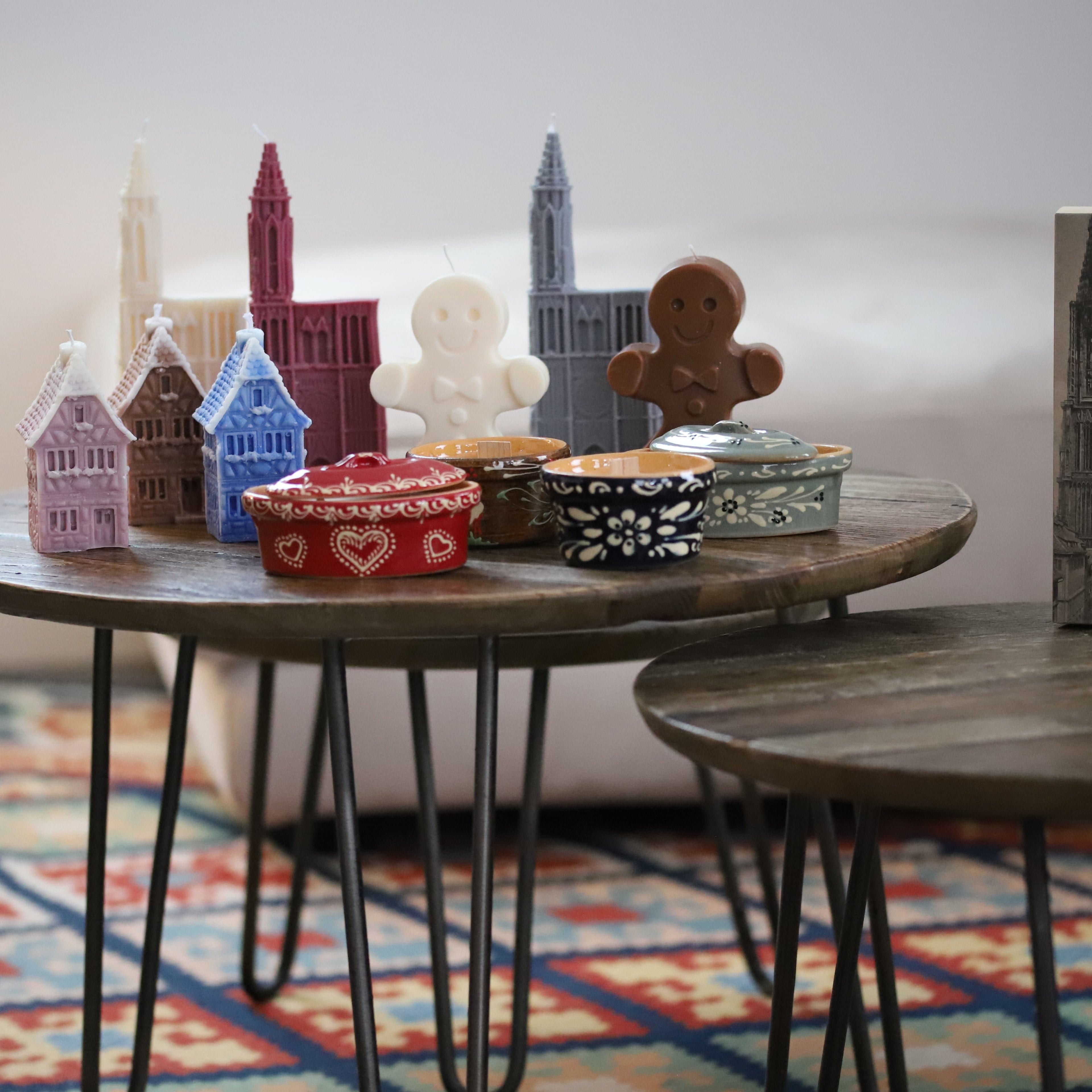 Bougies artisanales représentant des maisons alsaciennes, la cathédrale de Strasbourg et des bredeles, parfaites pour une décoration typique d'Alsace ou un souvenir original.