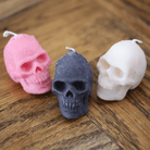 Bougies artisanales en forme de crâne, disponibles en noir, rose et blanc, parfaites pour une décoration originale et audacieuse, idéales pour Halloween ou une ambiance gothique.