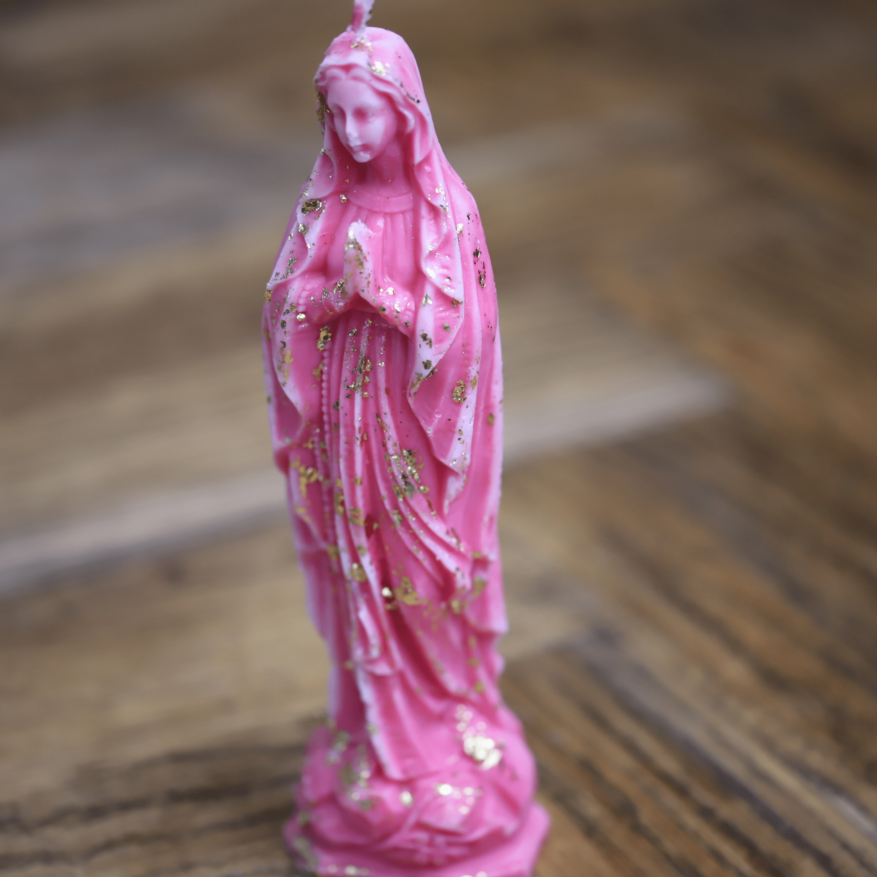 Bougie artisanale religieuse représentant la Vierge Marie en cire rose avec finitions dorées.