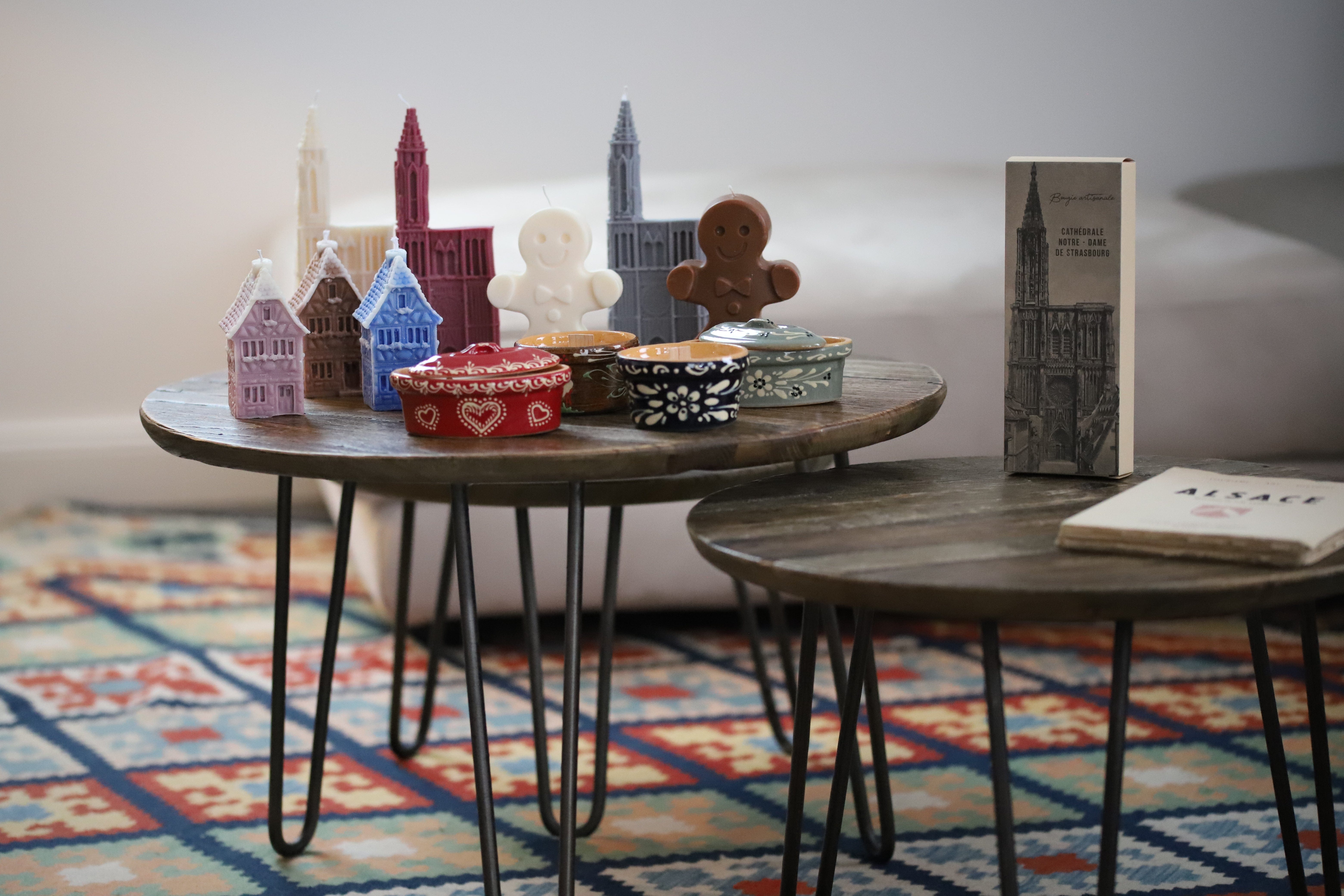Bougies artisanales représentant des maisons alsaciennes, la cathédrale de Strasbourg et des bredeles, parfaites pour une décoration typique d'Alsace ou un souvenir original.
